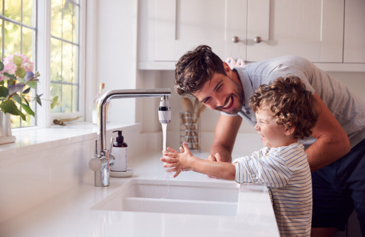 Father,Helping,Son,To,Wash,Hands,With,Soap,At,Home